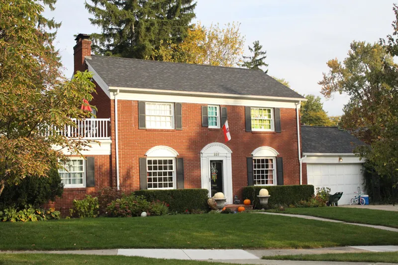 Red brick colonial with a black shingle roof.