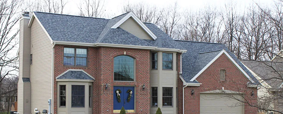 Two-story brick home with a gray architectural shingle roof.