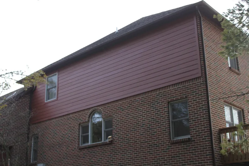 After: the same upper story with new red lap siding.